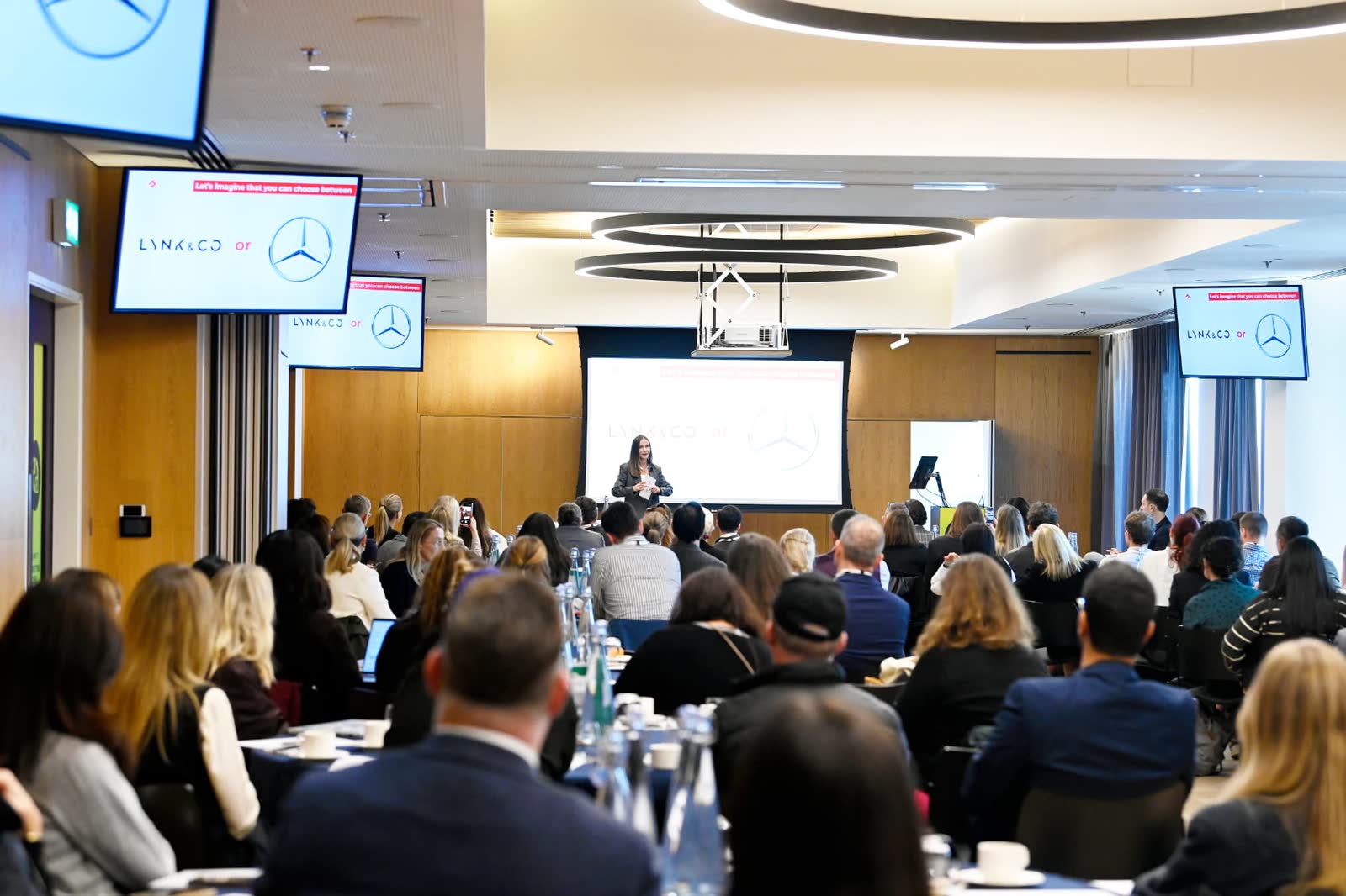 A speaker presenting to a full room of seated marketers at the 2025 Forum